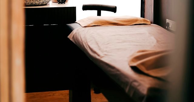Camilla de tratamiento vacía en una cabina de estética