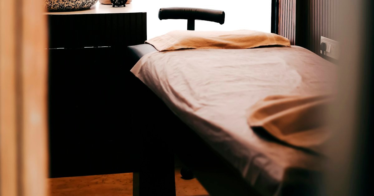 Camilla de tratamiento vacía en una cabina de estética